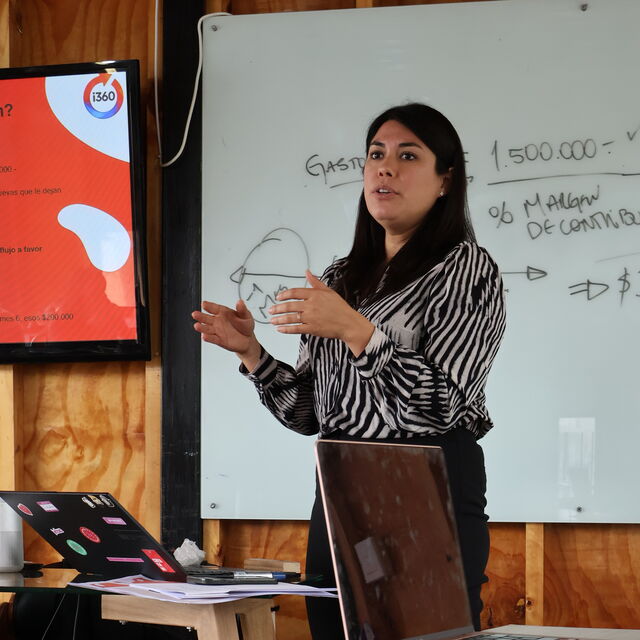 María José explicando el concepto de La Mochila (costos fijos) en un taller presencial